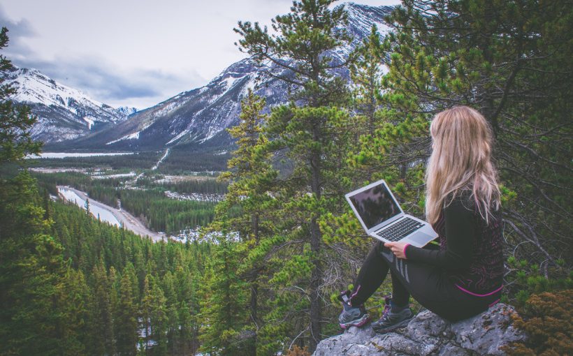 Young digital nomad works on a mountaintop