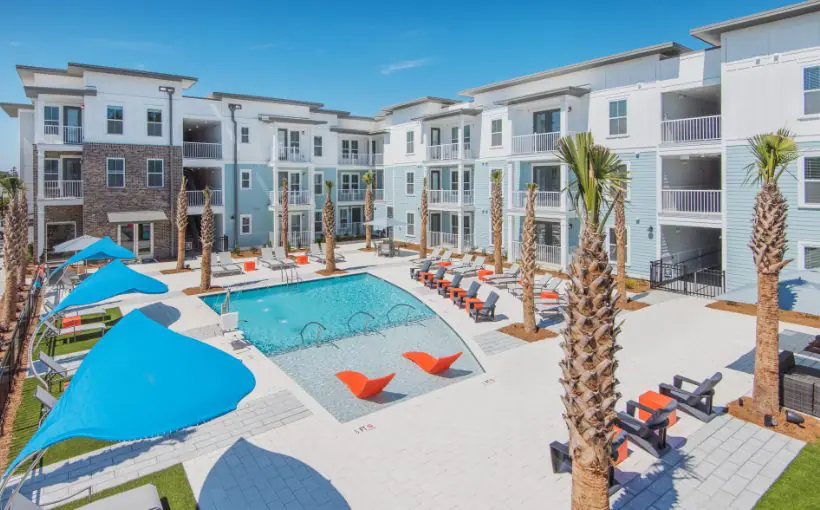 Exterior of a three-story apartment building with balconies surrounding pool deck