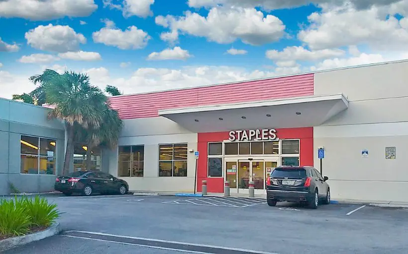 Front exterior parking lot view of single-tenant retail building with the Staples logo above the entrance door