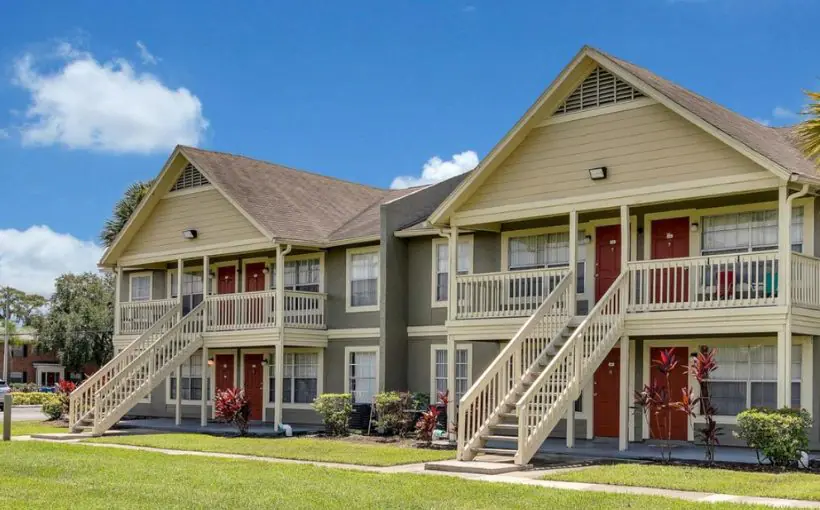 Front exterior view of a two story apartment complex with outside entrances facing lawn