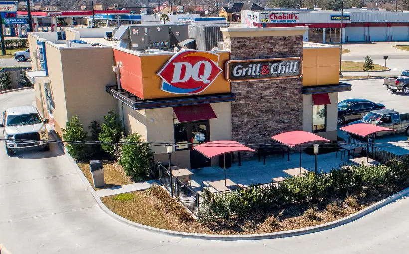 Aerial view of a Dairy Queen restaurant with drive through service and outdoor picnic tables