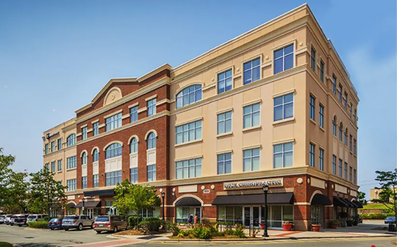 Front exterior view of brick-embellished office with covered drop-off area for visitors