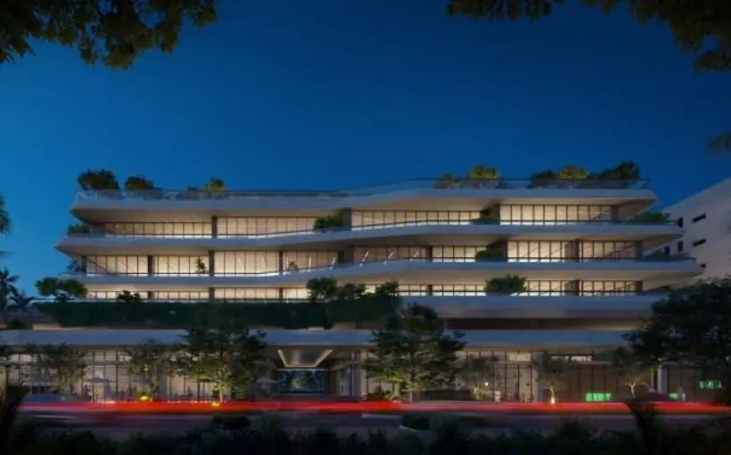 Exterior view of inner lit window-filled concrete office building at twilight