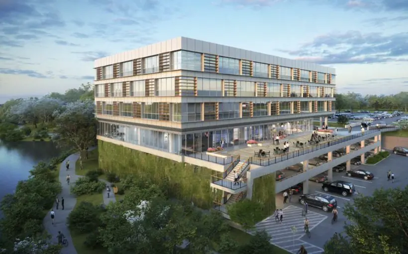 Artist rendering of window-filled mid rise office building with parking below, terrace with seating, and waterfront walkway behind.
