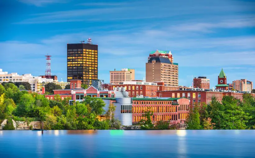 Long range cityscape view of tall office buildings and lake in downtown Manchester, NH