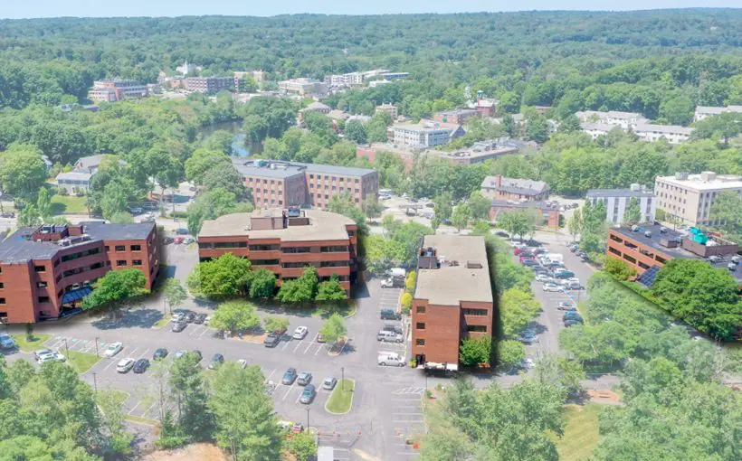 Aerial view of four brick mid rise office building surrounded by trees