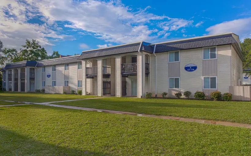 Exterior front view of a two story apartment building facing a lawn