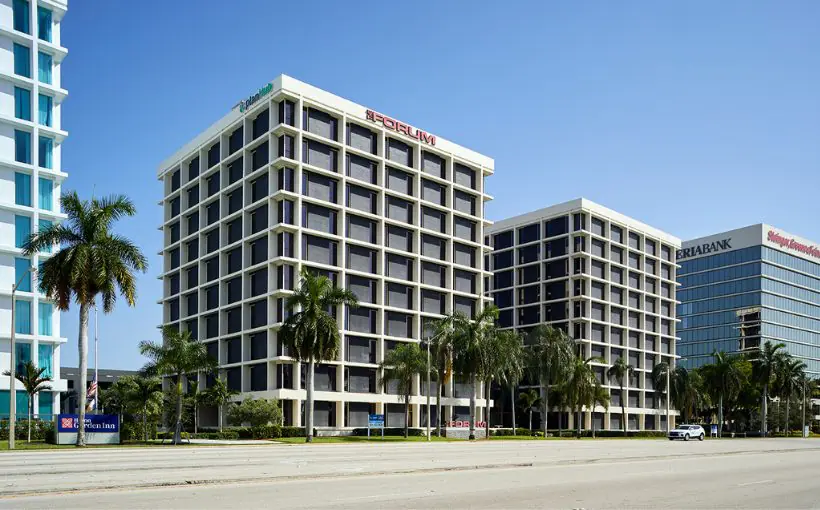 Exterior streetside view of two matching 10-story concrete office buildings with many windows