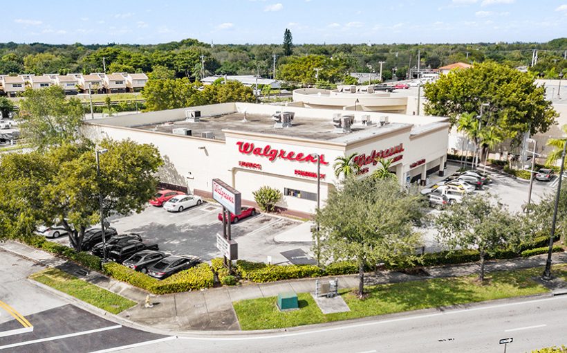 Aerial view of a stand-alone Walgreen store with front entrancing facing a busy intersection